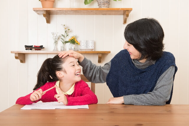 子供の頭をなでる親